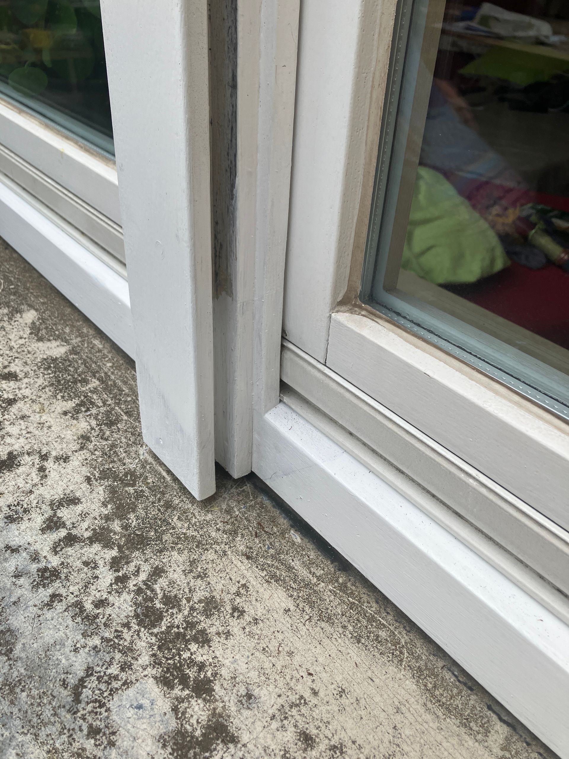 Erfolgreich reparierter und weiß neu lackierter Holzfensterrahmen an der Balkontür