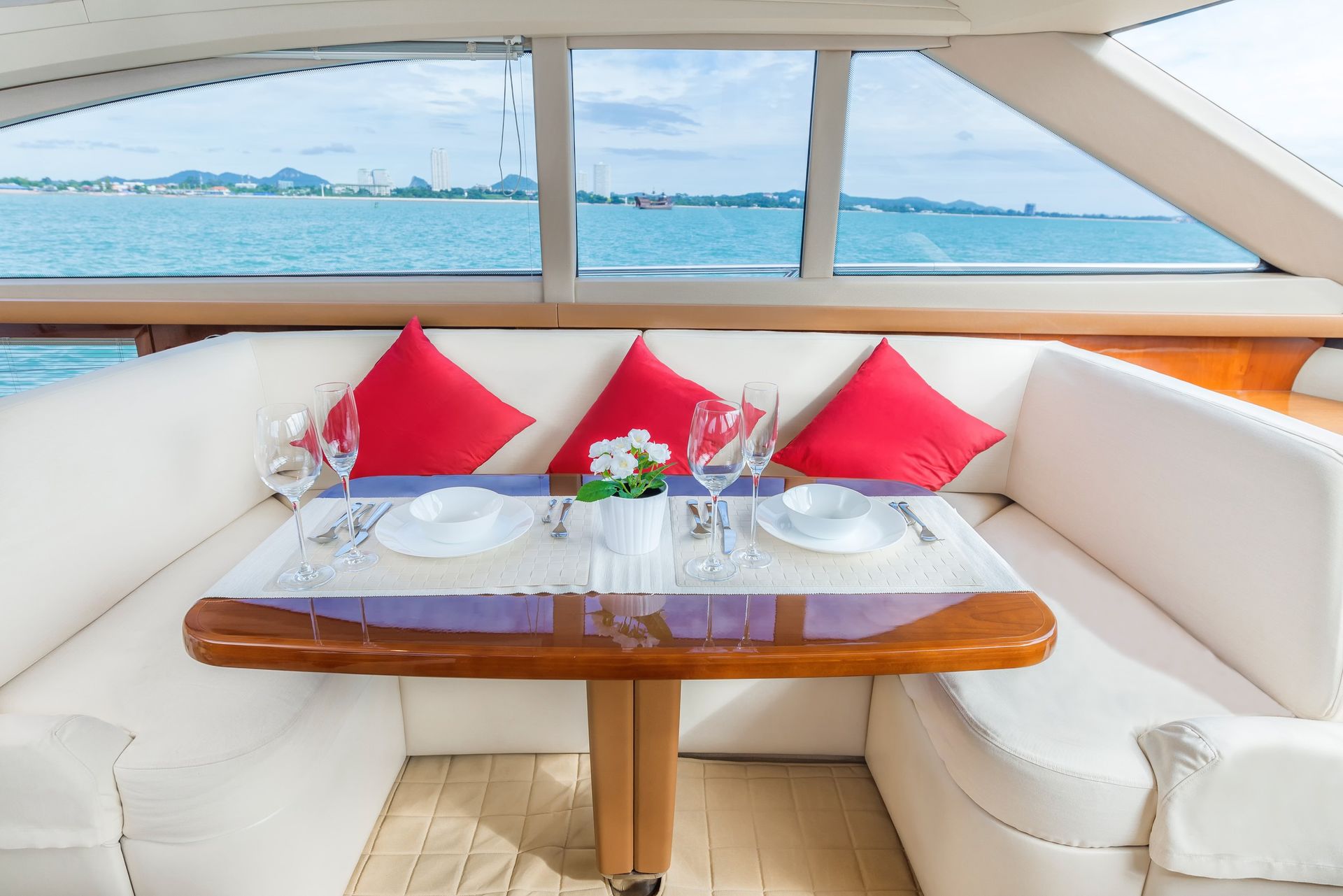 Un comedor en un barco con una mesa y vista al océano.