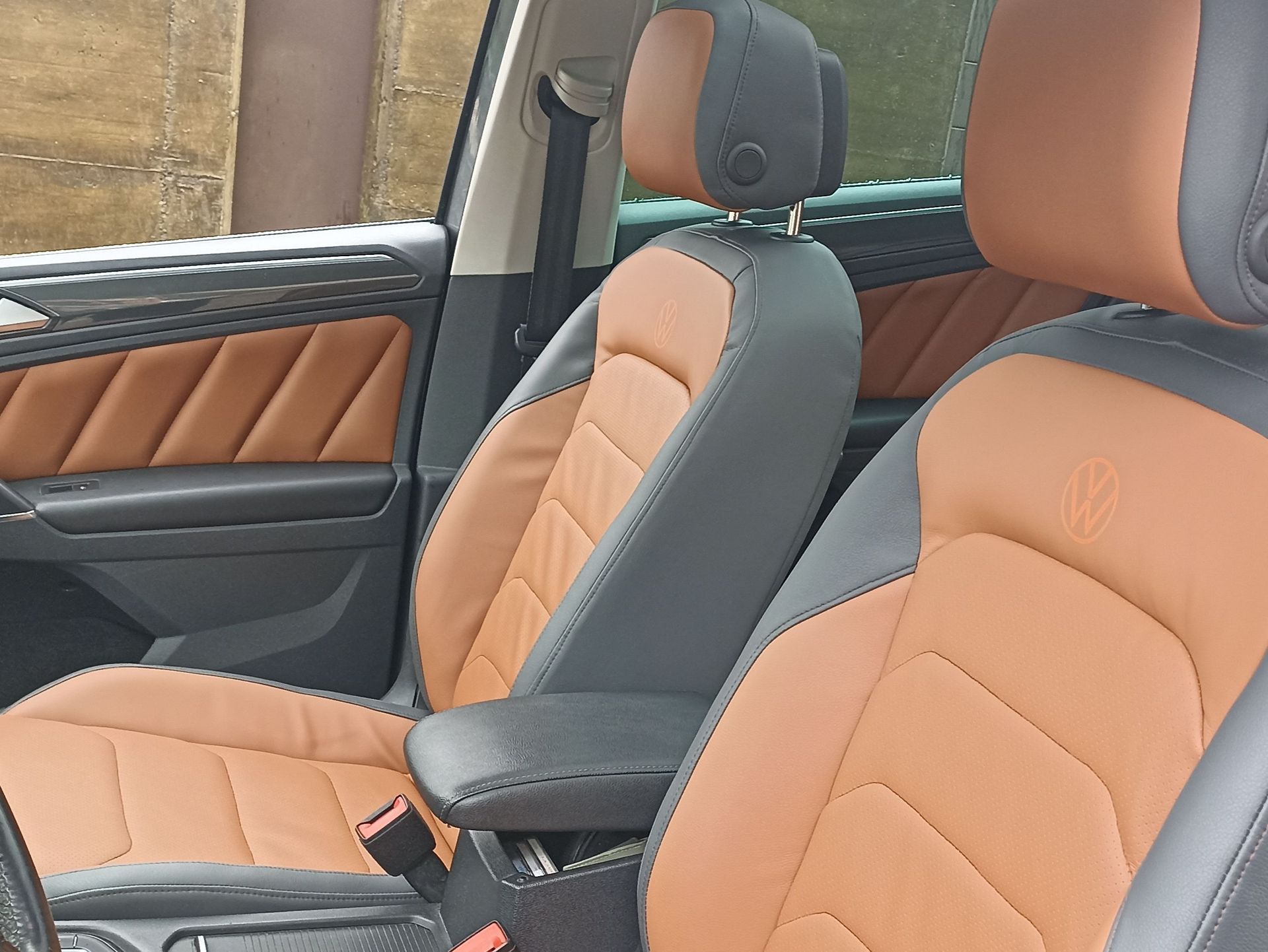 Los asientos delanteros de un automóvil Volkswagen son de color marrón y negro.
