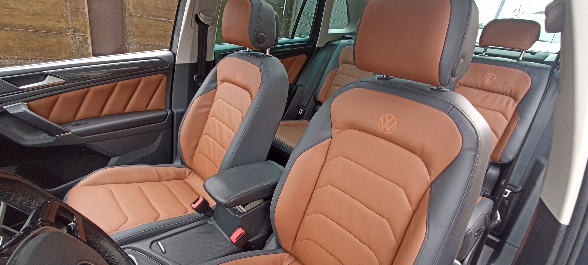 El interior de un coche con asientos de cuero marrón y negro.