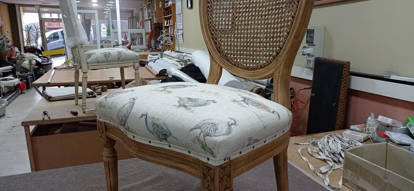 Una silla con respaldo de mimbre está colocada sobre una alfombra en una habitación.
