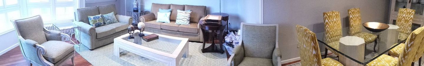 Una sala de estar con un sofá, sillas y una mesa.