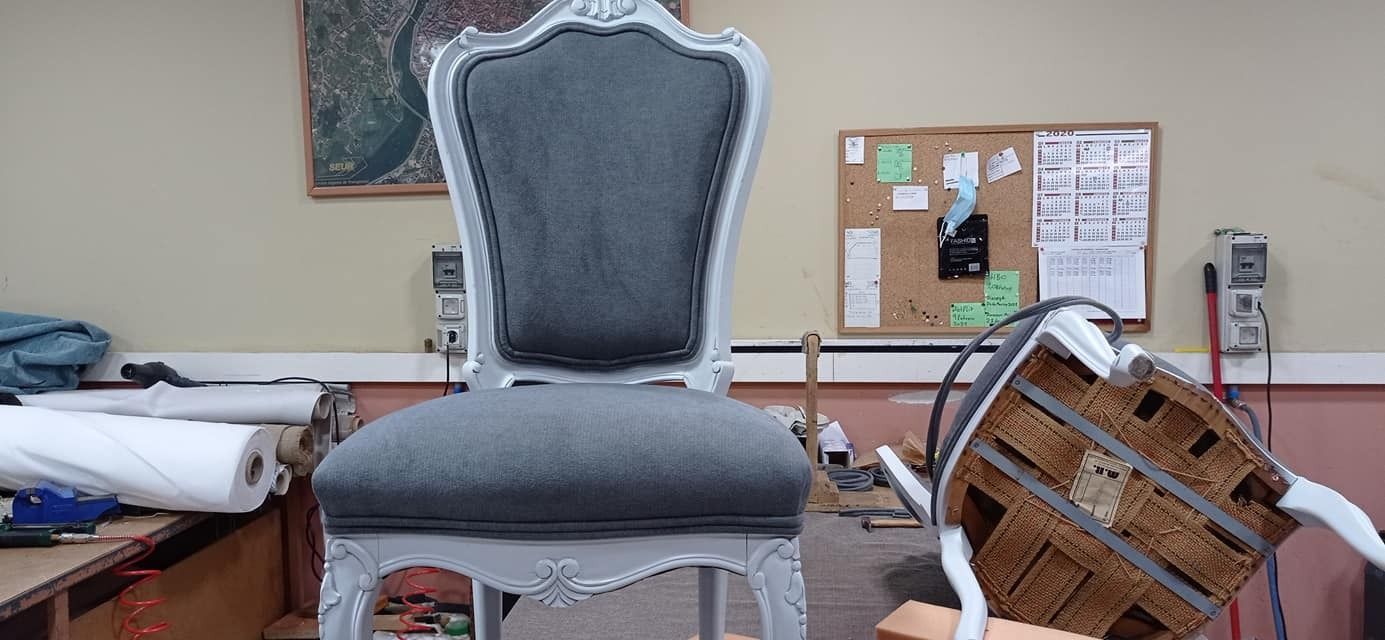 Una silla está colocada en una habitación con un tablón de anuncios en el fondo.