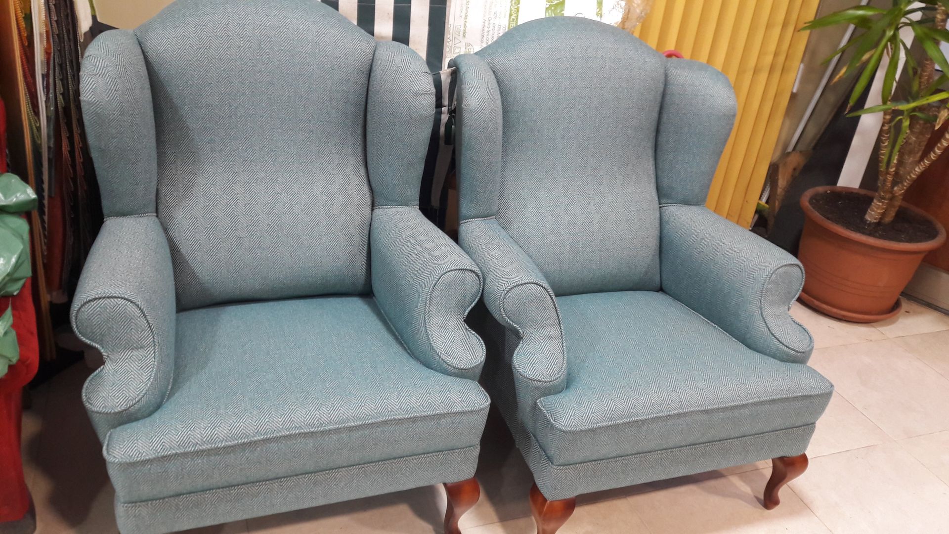 Dos sillas azules están una al lado de la otra en una habitación.