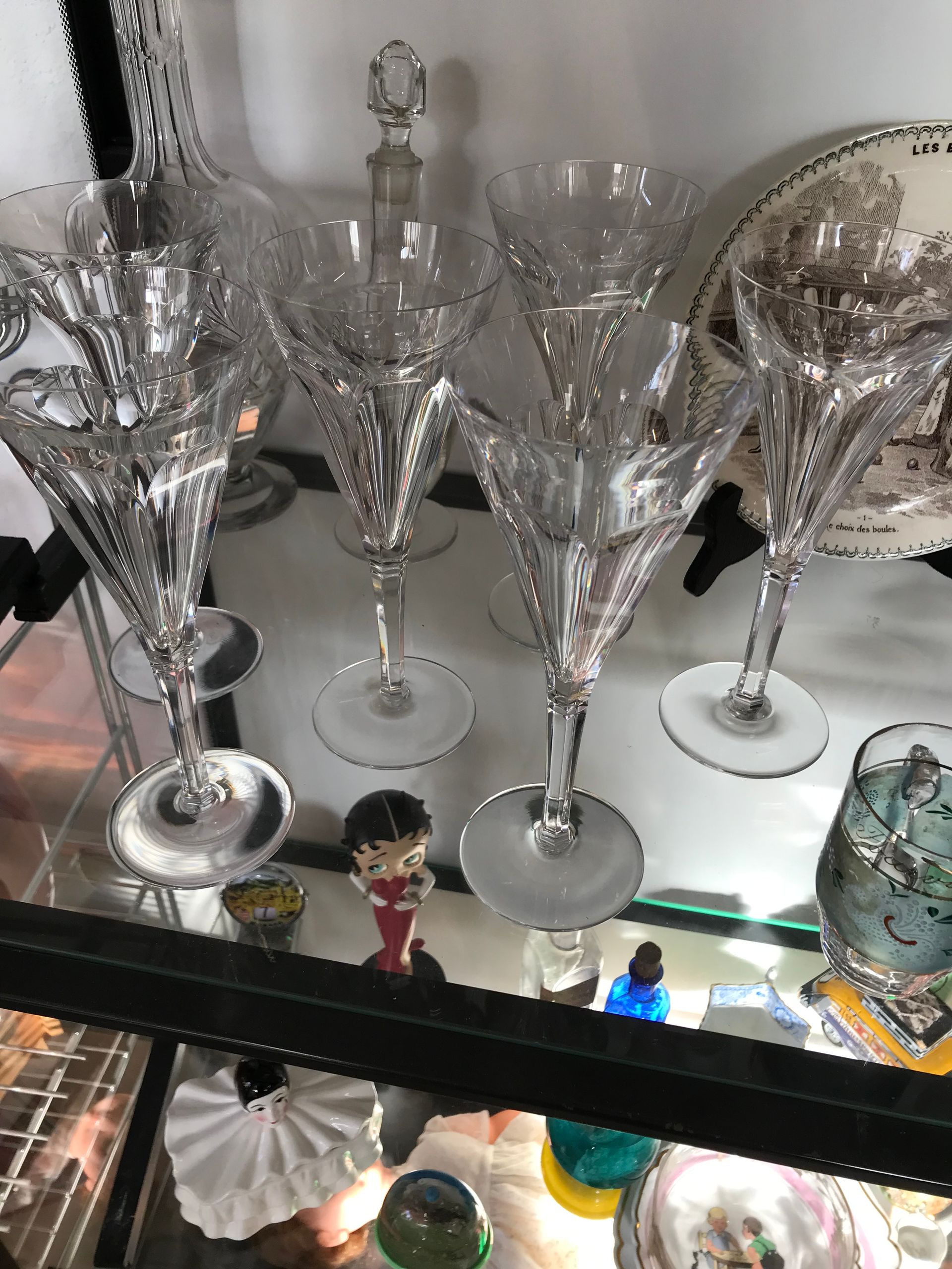 Verres à vin en cristal et carafe présentés dans une vitrine.