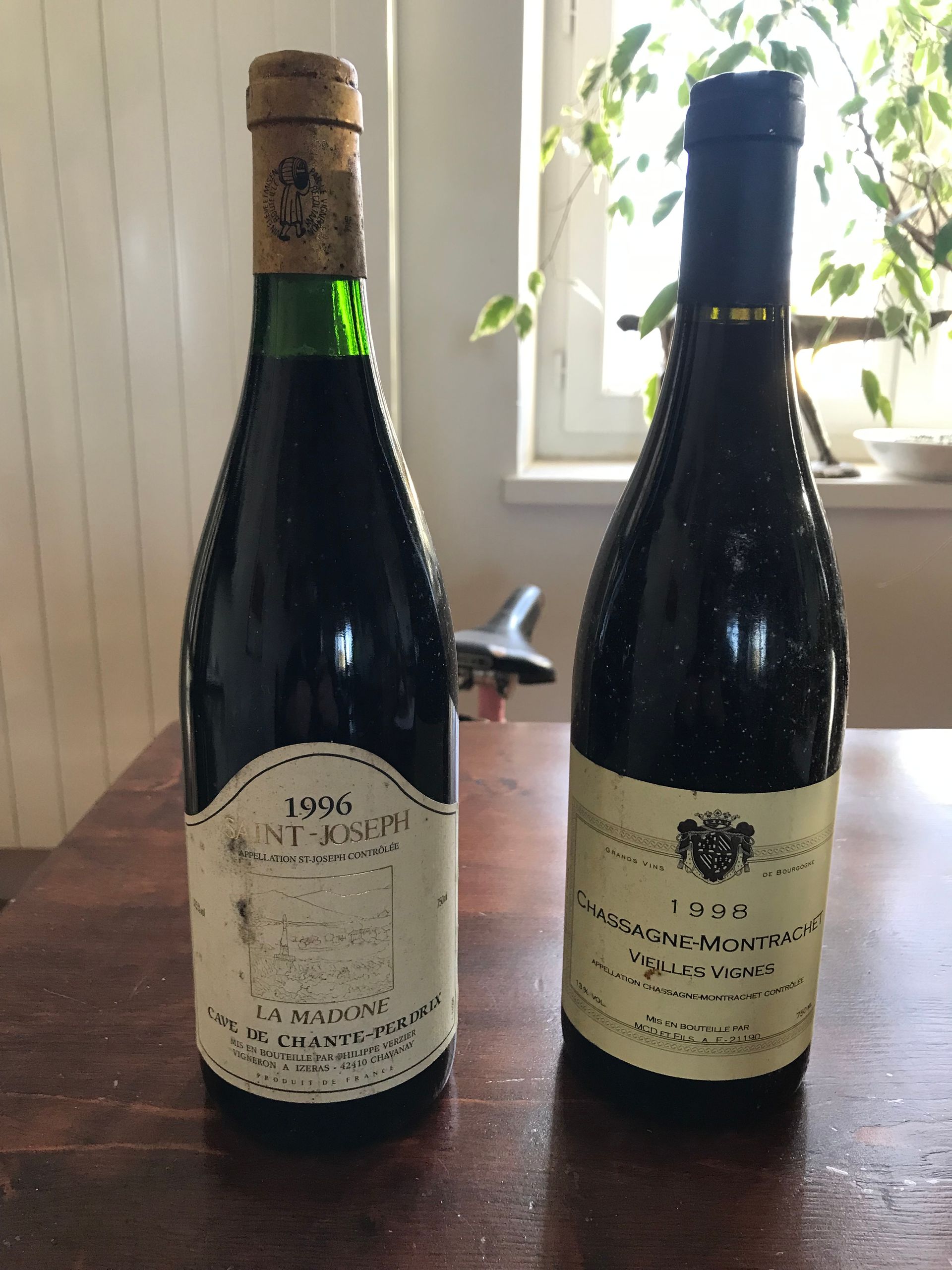 Deux bouteilles de vin millésimé sur une table ; la bouteille de gauche porte l'étiquette 1946 Saint-Émilion.