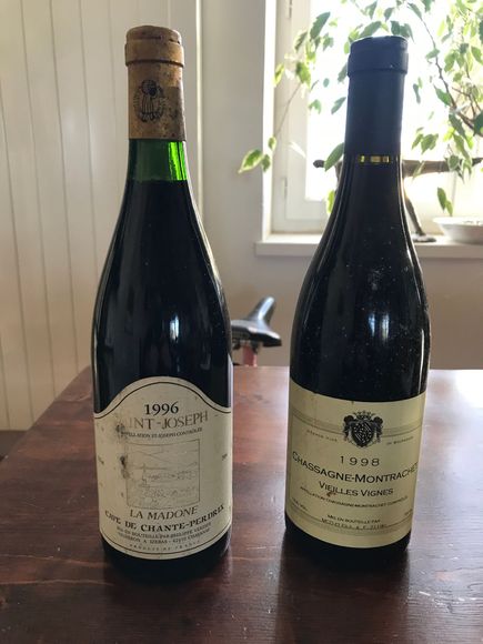 Deux bouteilles de vin millésimé sur une table ; la bouteille de gauche porte l'étiquette 1946 Saint-Émilion.