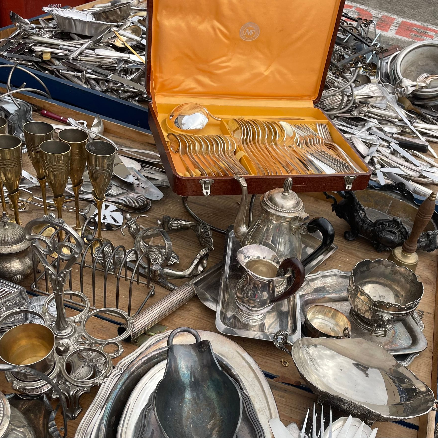 Une collection d'argenterie ancienne à vendre sur un marché en plein air.