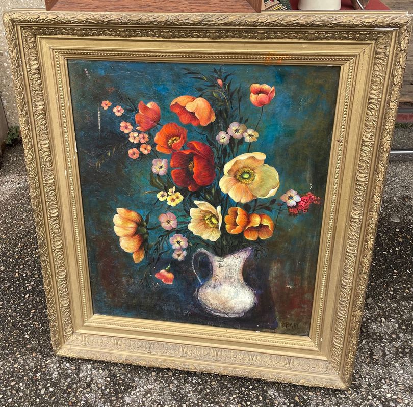 Peinture à l'huile représentant des fleurs dans un pichet, sur fond bleu foncé, dans un cadre doré orné.