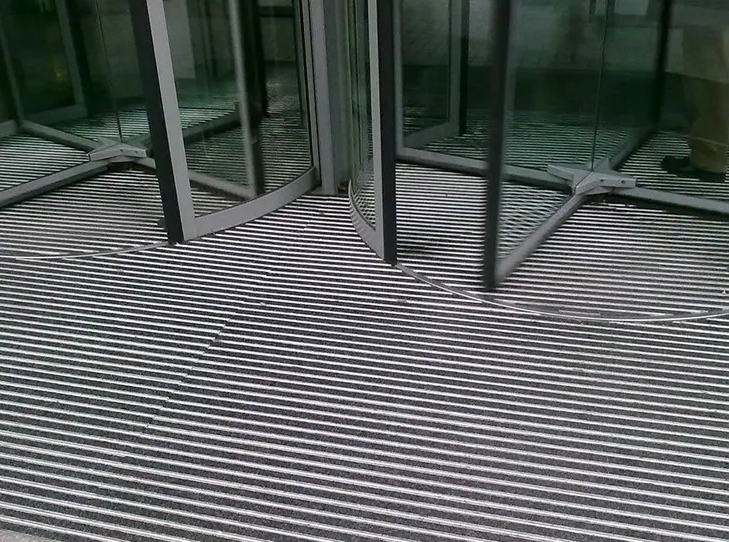 Salden u. Nicolaus Schlosserei GmbH - Eine schwarz-weiß gestreifte Matte liegt auf dem Boden vor einer Glastür.