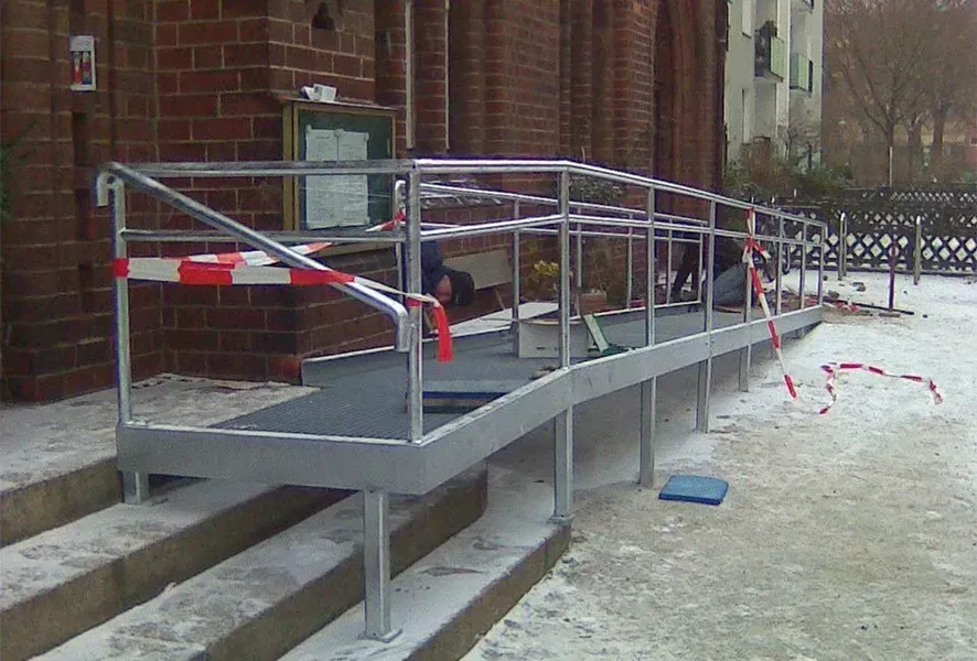 Salden u. Nicolaus Schlosserei GmbH - Vor einem Backsteingebäude wird eine Rampe gebaut