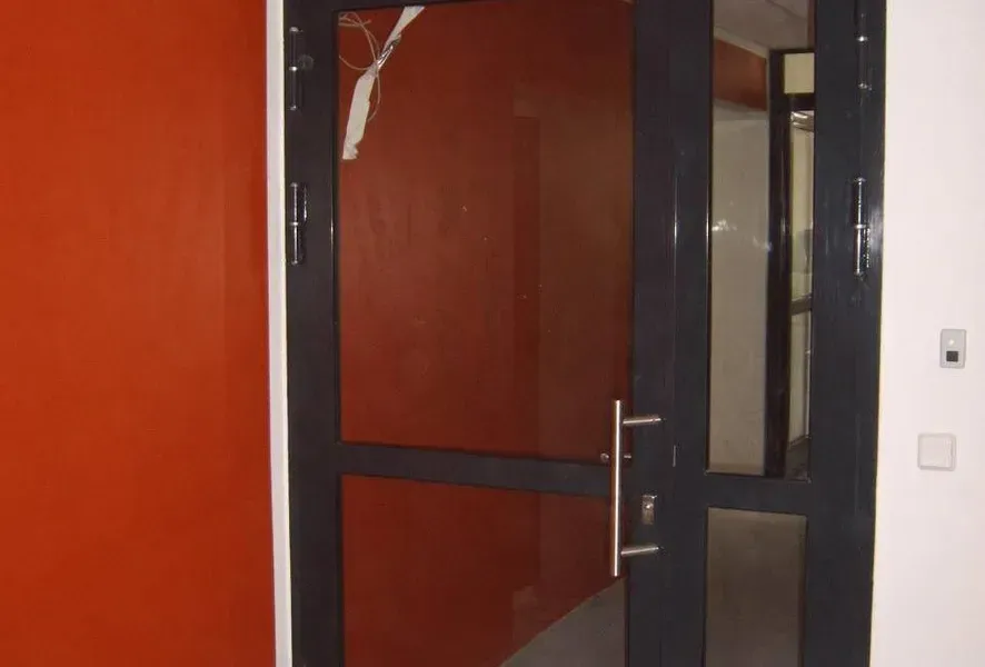 Salden u. Nicolaus Schlosserei GmbH - Eine schwarze Tür mit einer roten Wand dahinter