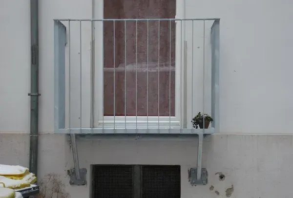 Salden u. Nicolaus Schlosserei GmbH - Ein weißes Gebäude mit einem Balkon und einem Fenster.