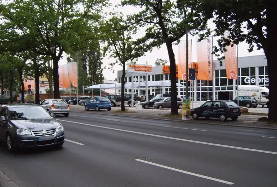 Salden u. Nicolaus Schlosserei GmbH - Autos fahren eine Straße entlang vor einem Gebäude mit der Aufschrift „Getriebe“