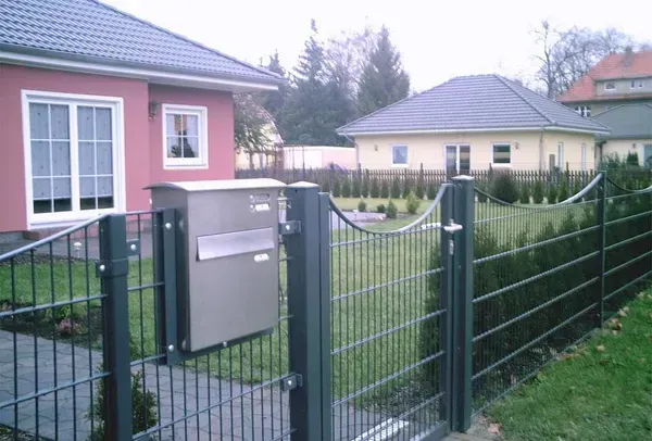 Salden u. Nicolaus Schlosserei GmbH - Ein Briefkasten steht hinter einem Zaun vor einem Haus