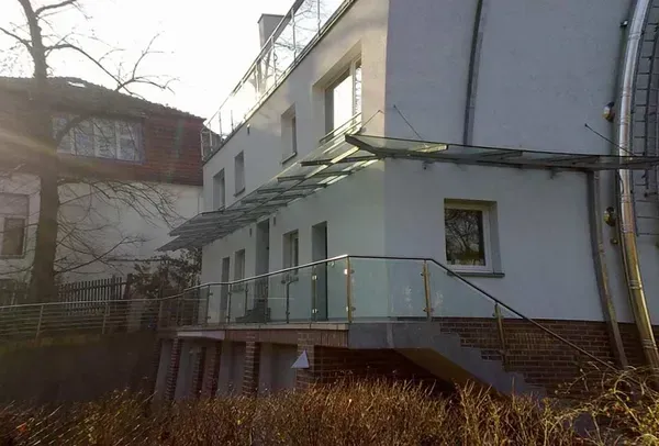 Salden u. Nicolaus Schlosserei GmbH - Ein weißes Gebäude mit einem Glasbalkon und Treppen