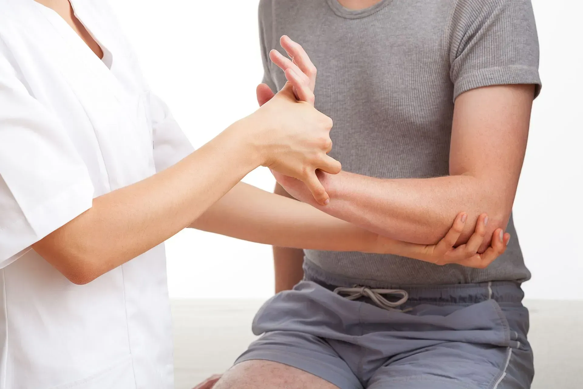 Une infirmière examine le coude et le poignet d'un patient.