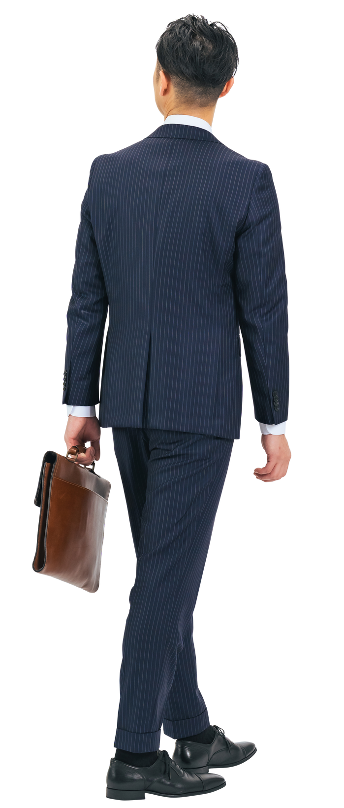 Un homme en costume bleu marine portant une mallette marron.