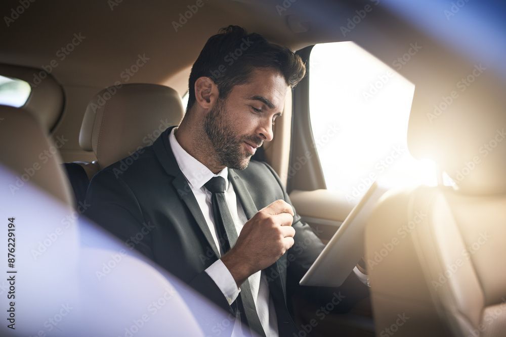 Ein Mann in Anzug und Krawatte sitzt auf dem Rücksitz eines Autos und nutzt ein Tablet.