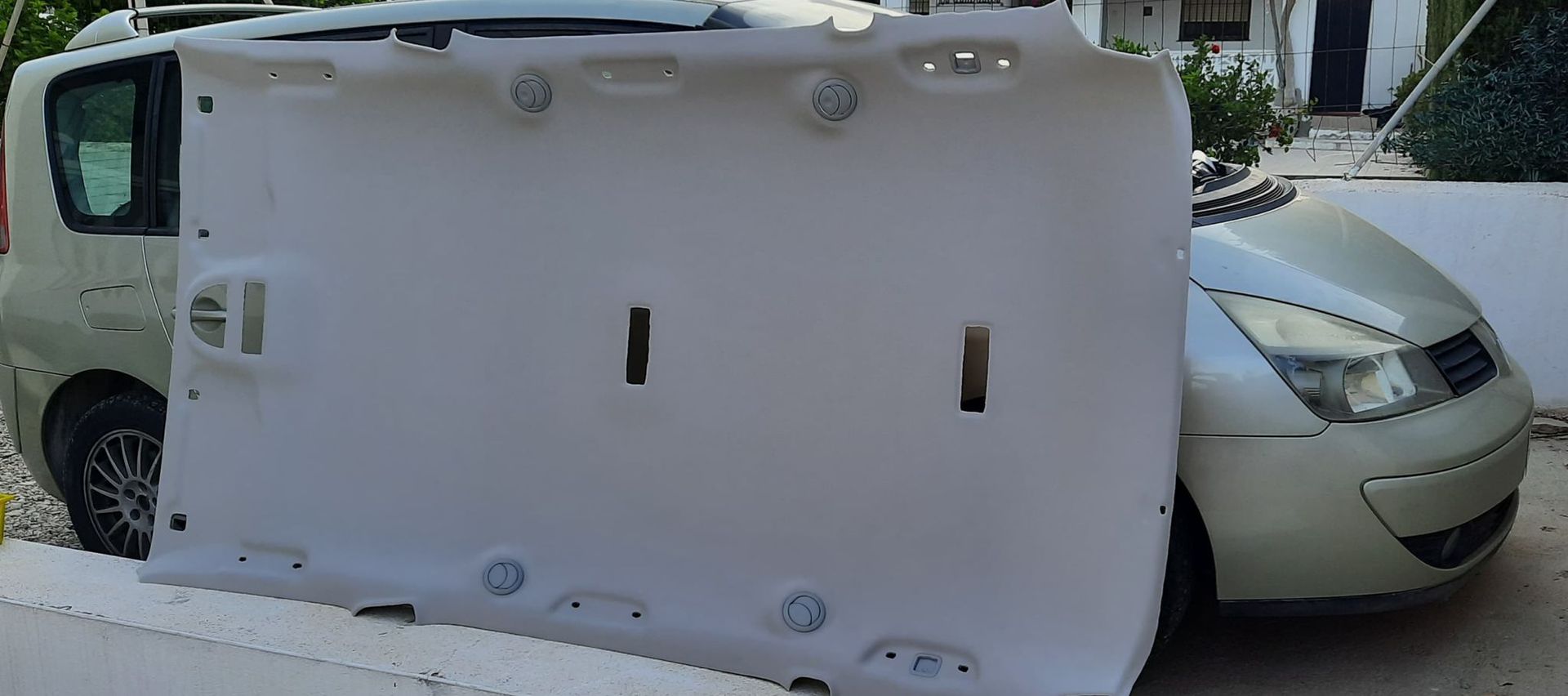 Una furgoneta blanca volcada bloquea el paso a un coche plateado en la calle.