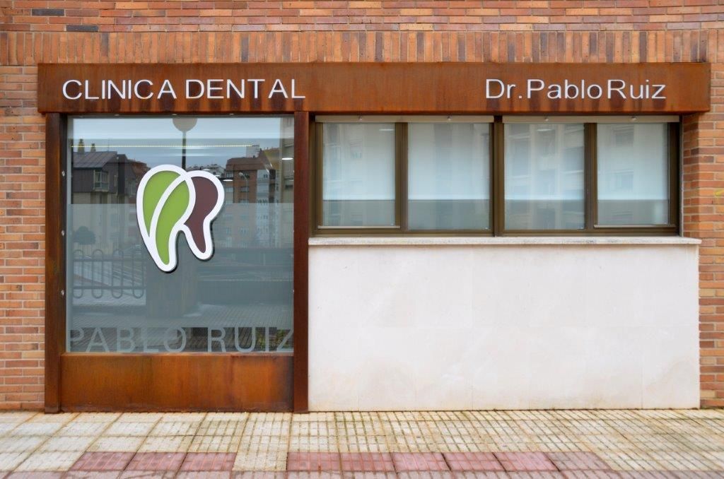 Un edificio de ladrillos con un cartel que dice clínica dental.