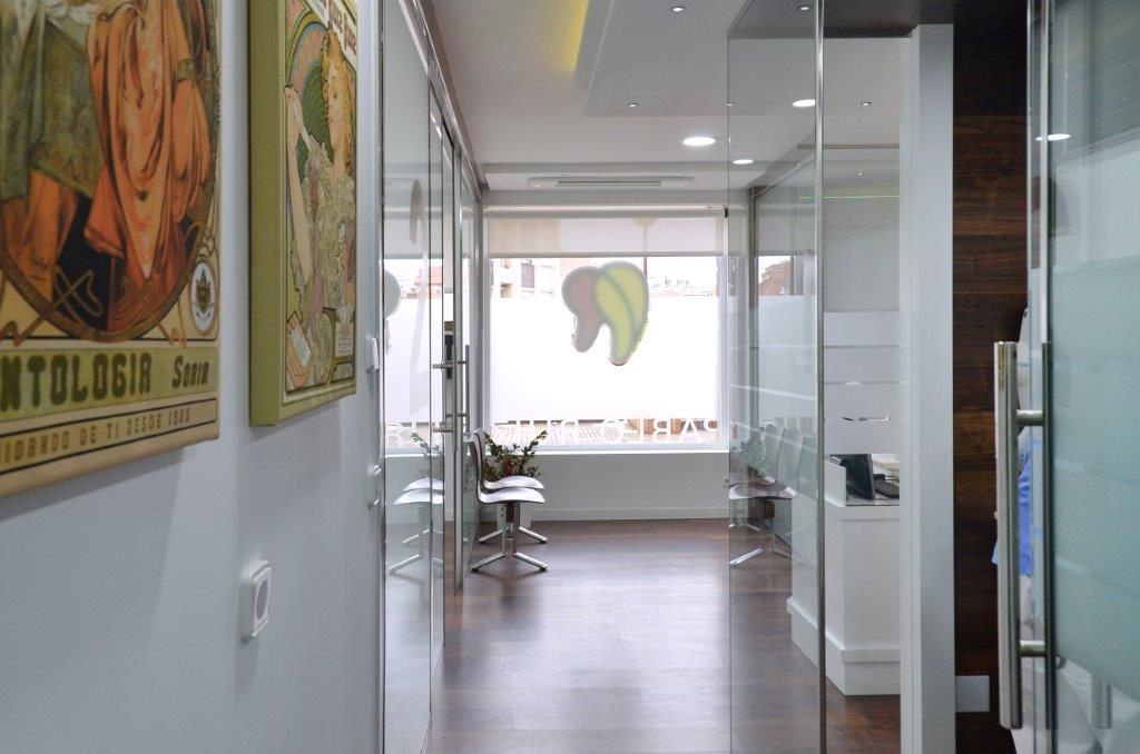 Un pasillo en un consultorio dental con un cuadro en la pared.