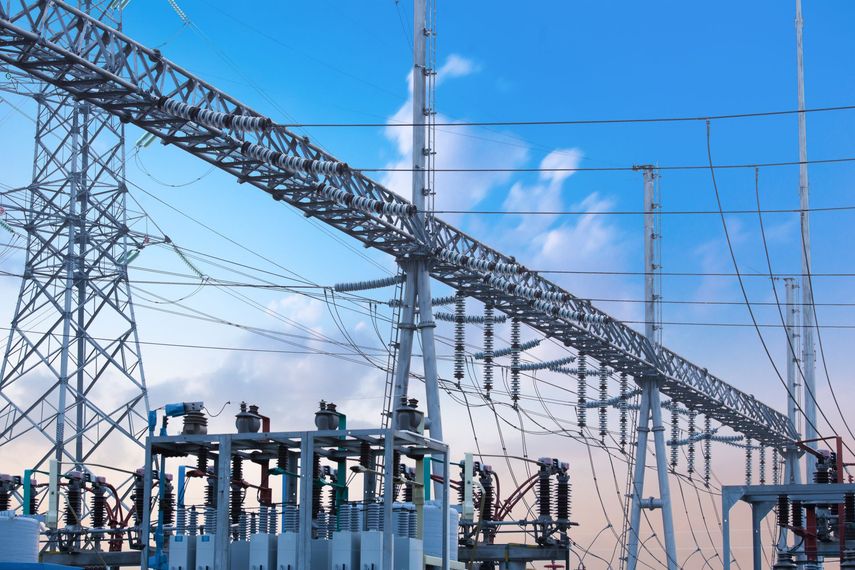 Poste de transformateur à haute tension avec pylônes et lignes de transport sous un ciel bleu