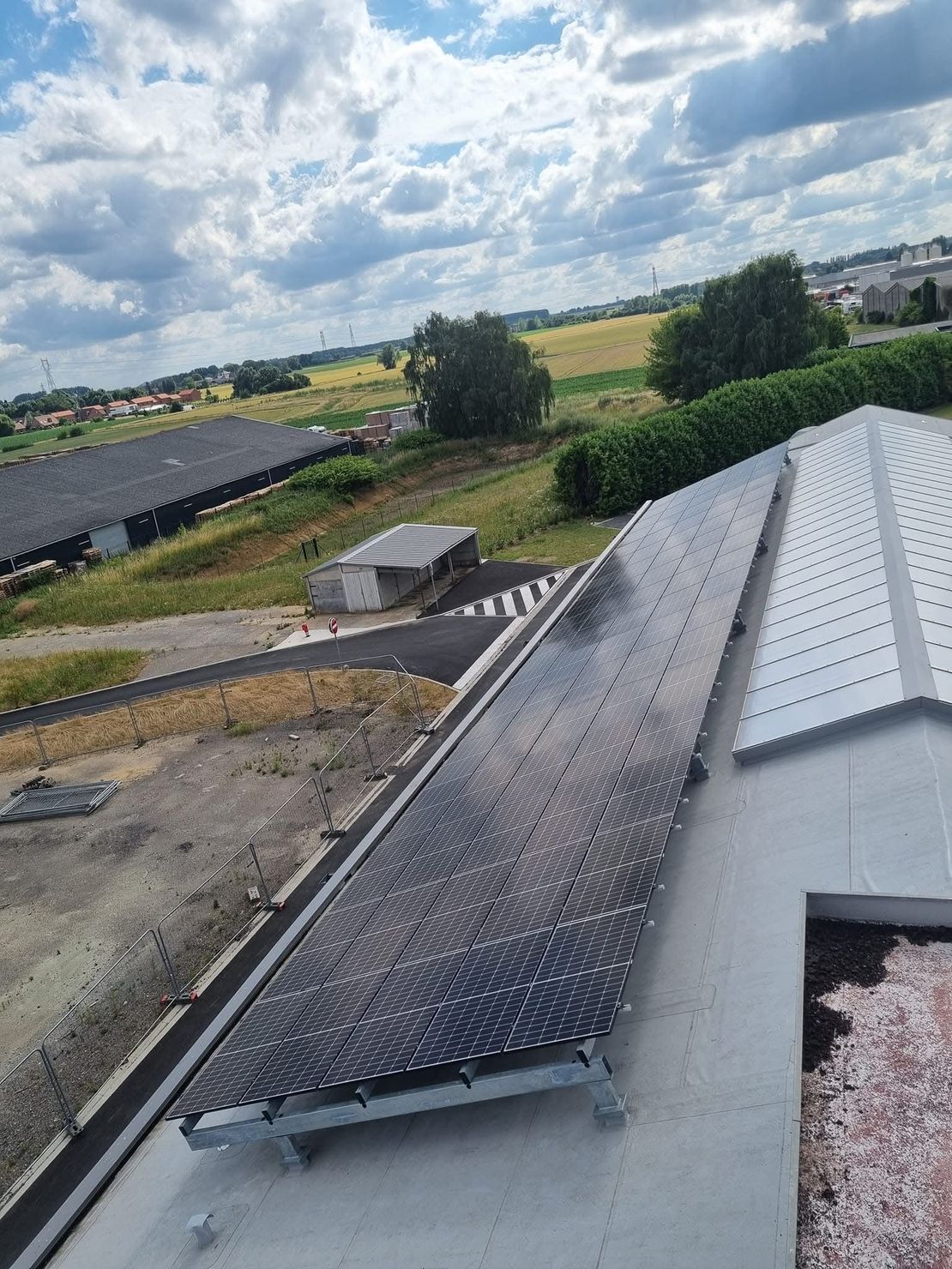 Un technicien nettoie des panneaux solaires sous un ciel bleu.