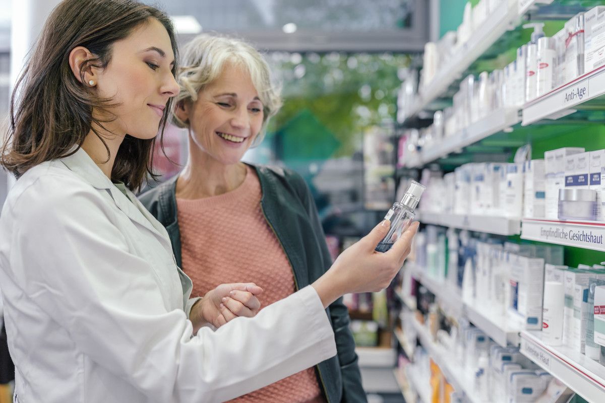 Pharmacienne présentant un produit à une dame.