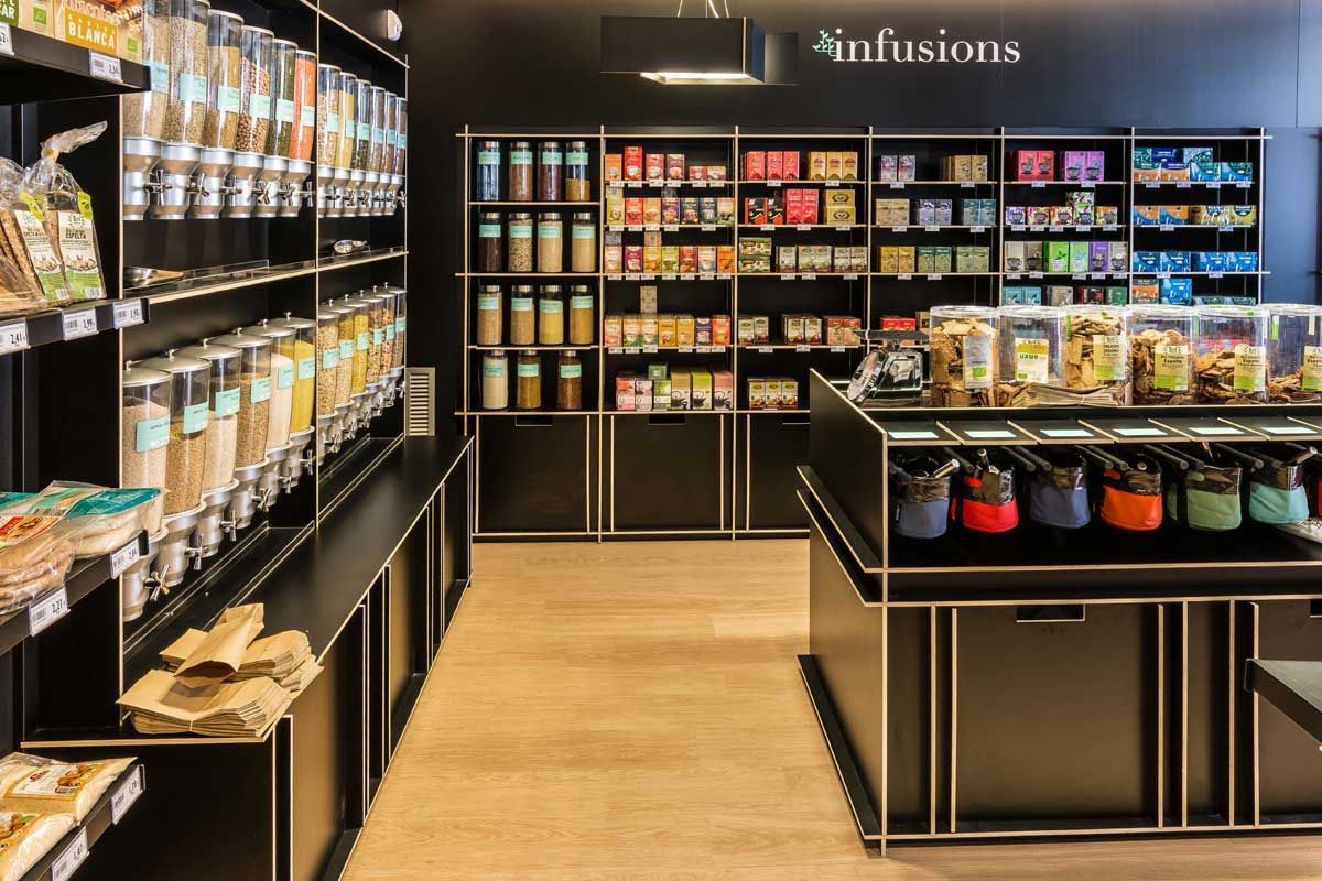 Una tienda de comestibles llena de muchos estantes y contenedores de comida.