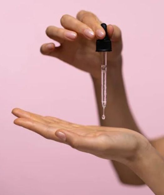 Una mujer sostiene un gotero en su mano.