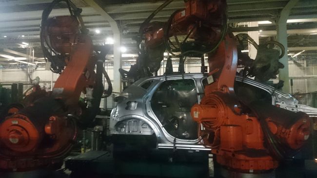 Un grupo de robots está trabajando en un automóvil en una fábrica.