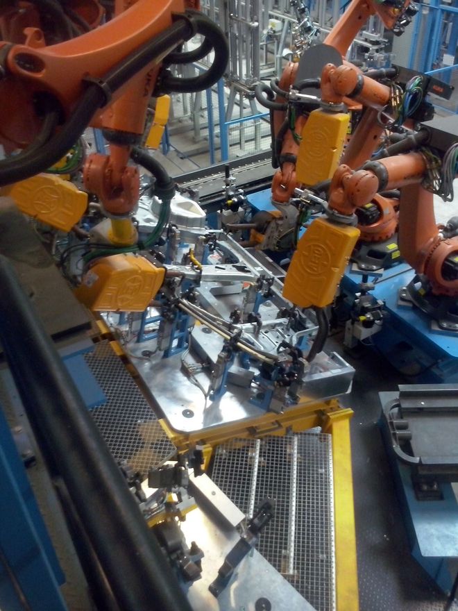 Un grupo de robots están trabajando en un trozo de metal.