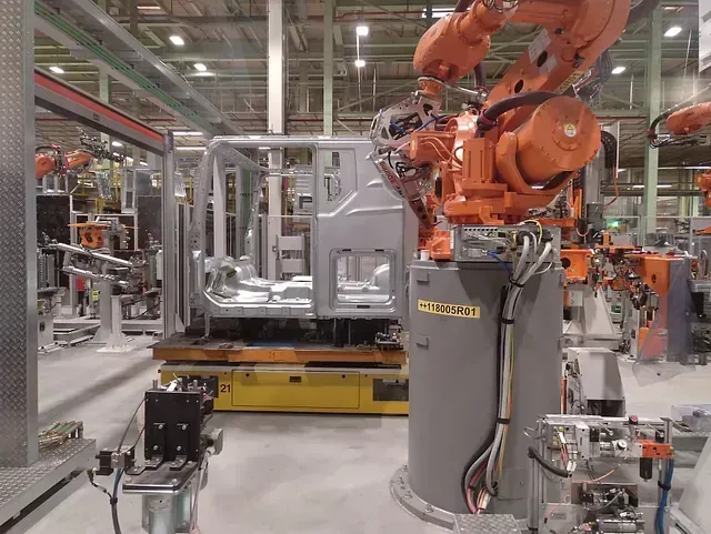 Una fábrica con muchos robots trabajando en una máquina