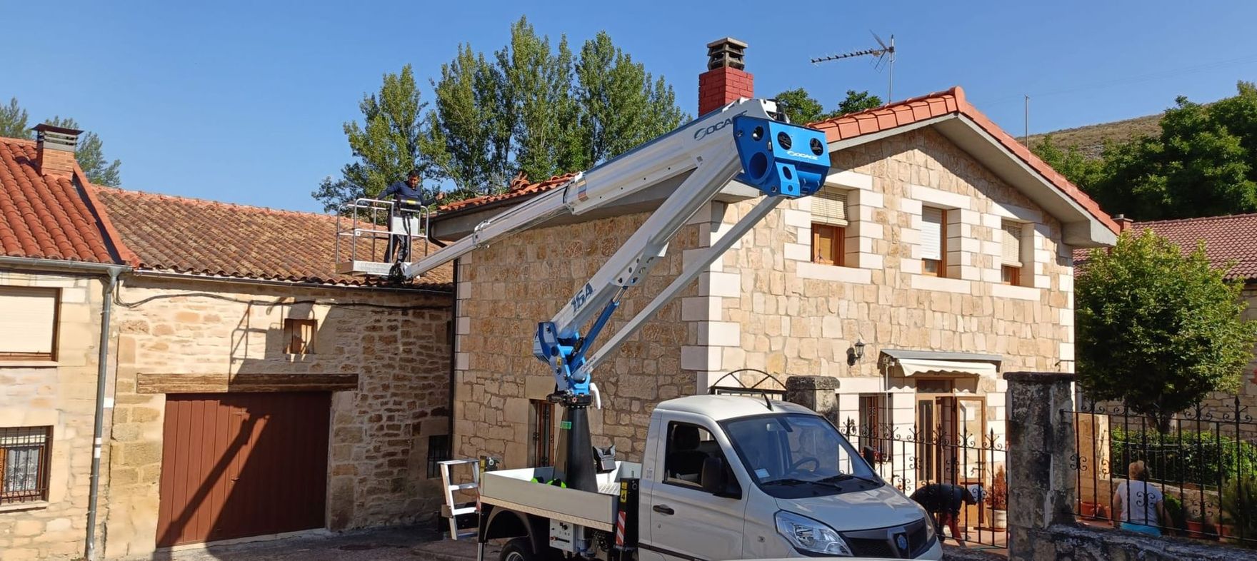 Un camión con una grúa encima está estacionado frente a una casa.