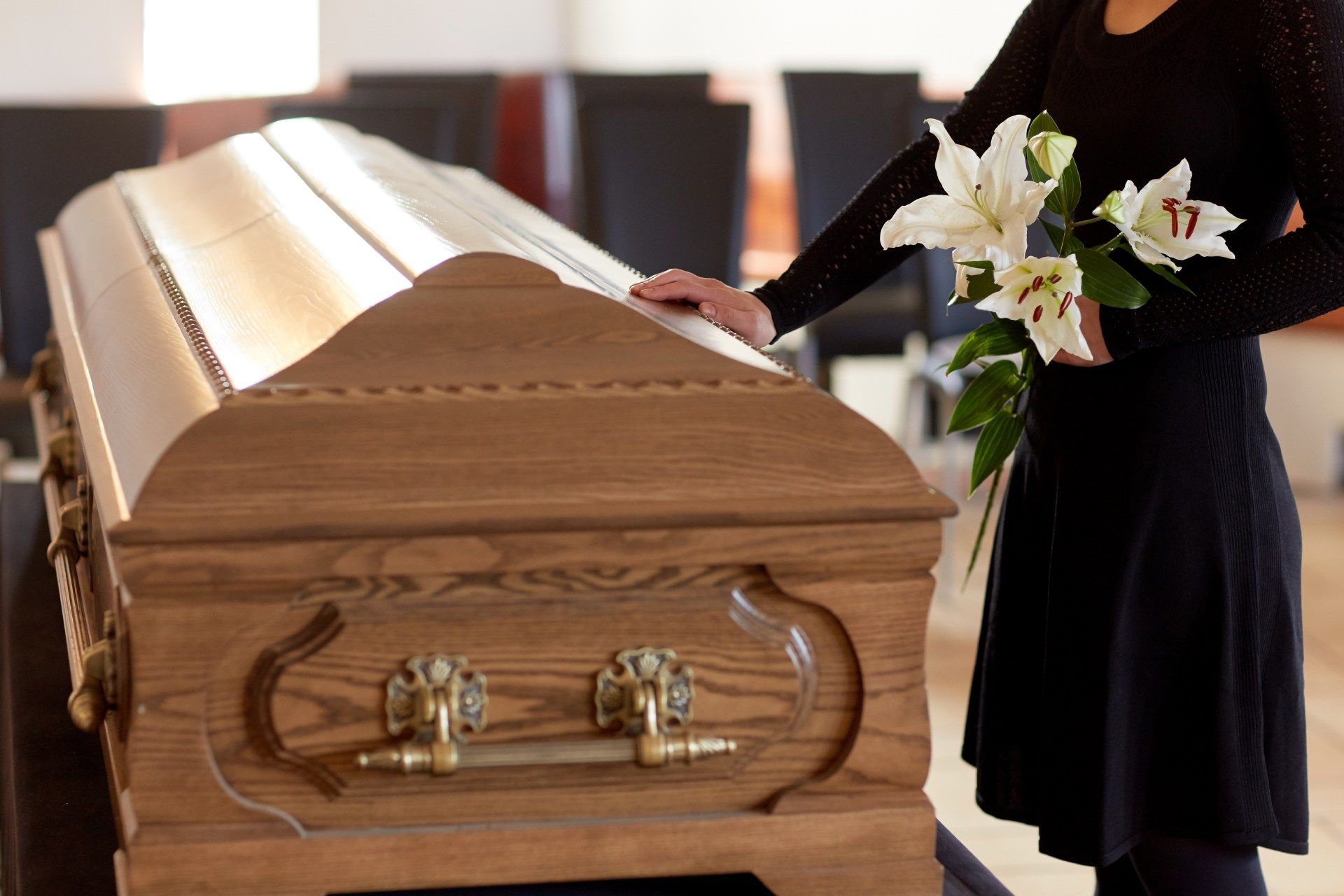 Trauender steht am Sarg