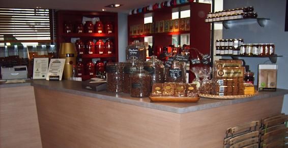 Un comptoir de magasin avec des bocaux de produits, des étagères de thé et de snacks.