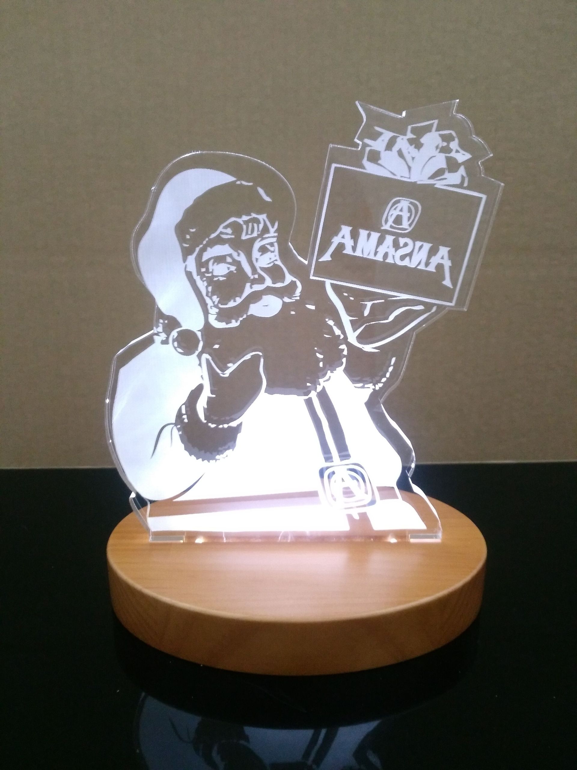 Un Papá Noel iluminado sosteniendo un cartel que dice 