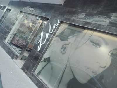 Una fotografía en blanco y negro del rostro de una mujer en el escaparate de una tienda.