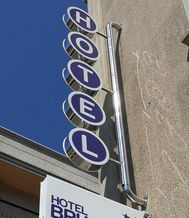 Un cartel de hotel cuelga del costado de un edificio.