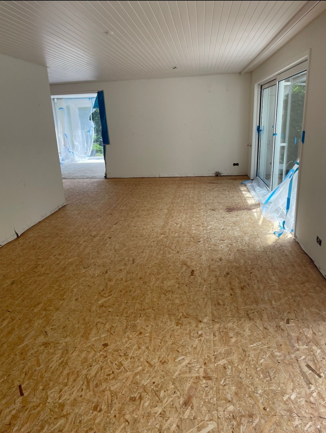 ein leerer Raum mit Holzboden und weißen Wänden.