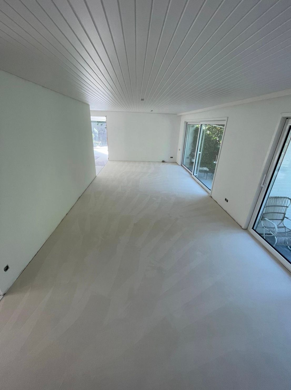 ein großer leerer Raum mit vielen Fenstern und einer weißen Decke.