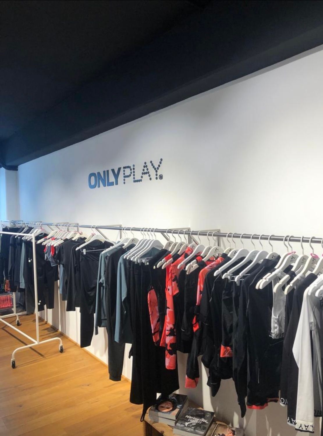 ein Laden voller Kleidung und ein Schild mit der Aufschrift „ONLY PLAY“.