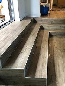 Eine Treppe aus Holz und Fliesen in einem Wohnzimmer.