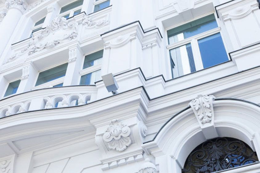 ein weißes Gebäude mit einem Balkon und einer Tür.