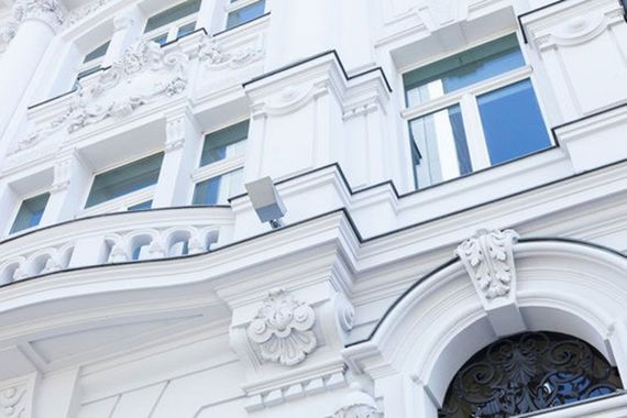 ein weißes Gebäude mit einem Balkon und einer Tür.