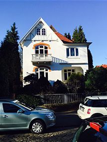 ein weißes Haus mit davor geparkten Autos