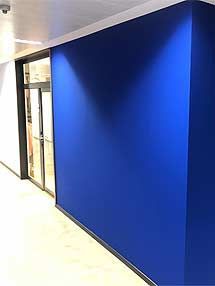 ein Flur mit einer blauen Wand und einer Glastür.