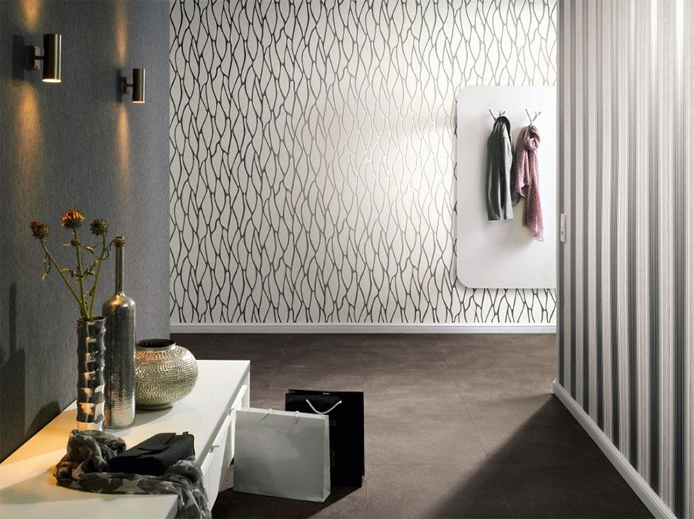 ein Flur mit einer gestreiften Wand und einer weißen Wand mit einem Muster darauf