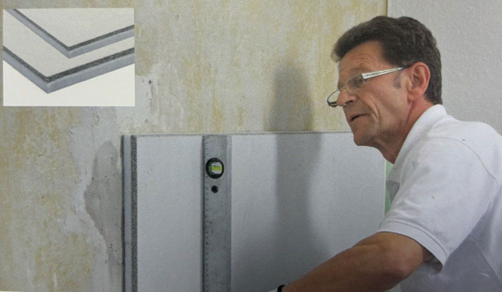 Ein Mann misst eine Wand mit einer Wasserwaage.